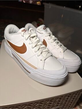 Stylish low-top Nike Court Legacy sneakers in white with a brown Swoosh.